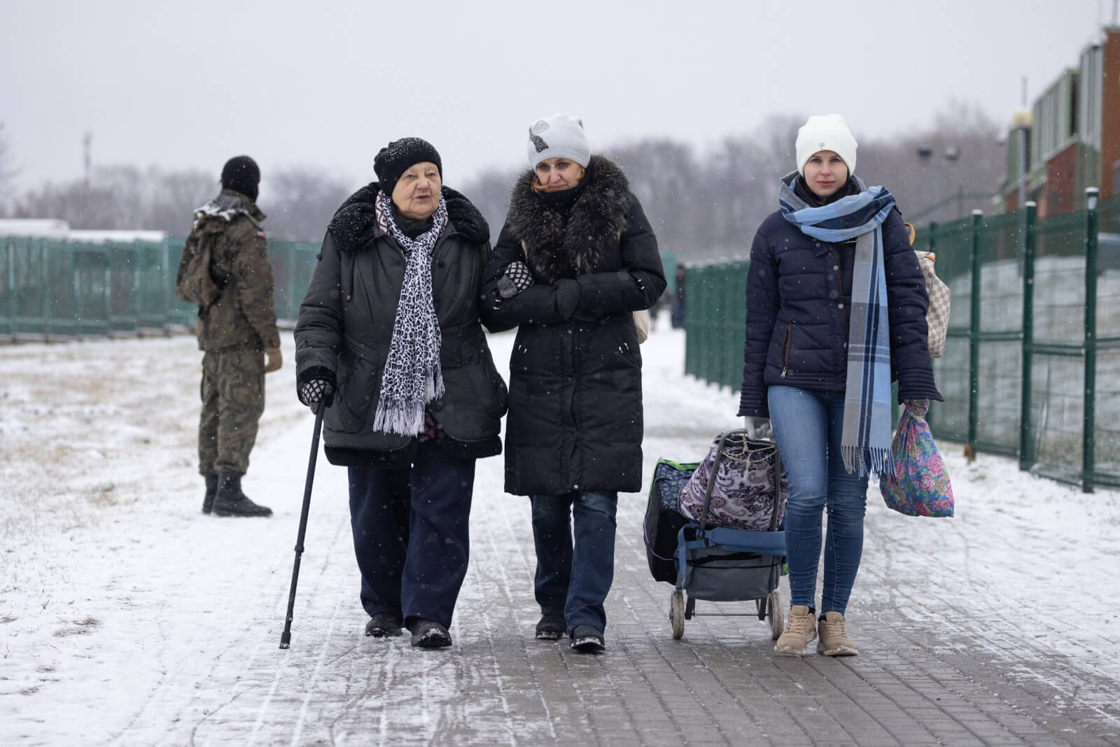 09/03/2022. Przemysl Poland. Svetlana age 77(L) her granddaughter Anna (C) and daughter Julia (R) from Ukraine cross the Medyka border crossing from Ukraine to Poland. Svetlana has to walk with a stick due to her age. The family drove two days with Anna's father from Naples Italy to reach the border and now they will drive the return journey with Svetlana. Anna said: we looked at the possibilities of how to take her [Svetlana] and the only one was to go by car from the south of Italy to here. We were driving for two days. We will stay in a hotel and then go two days by car back to Napoli. Over two million people have now left Ukraine since Russia invaded the country on 24 February 2022.